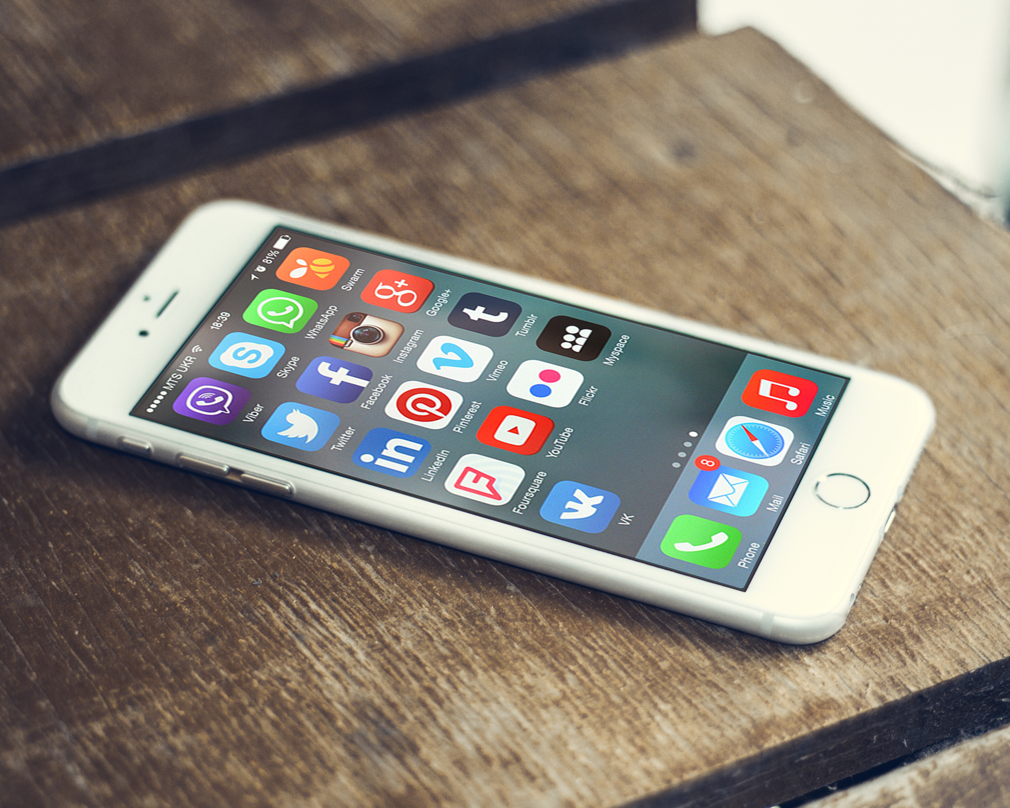 Smartphone screen with social media app icons beside a website layout